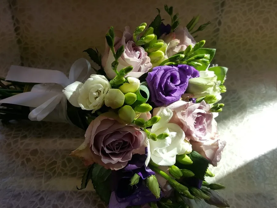 Buchet legat manual cu trandafiri roz-prăfuit, lisianthus mov și frezii albe